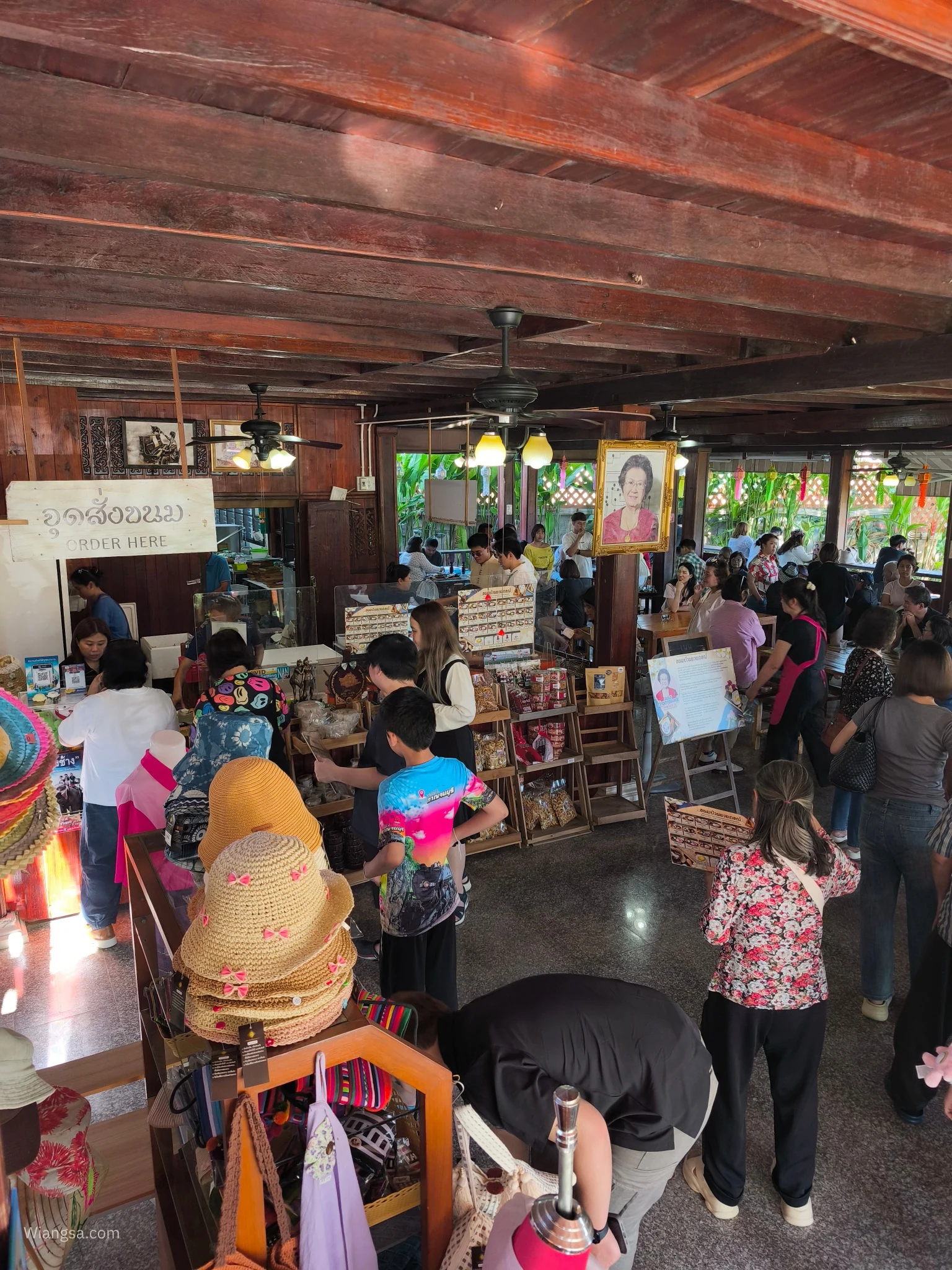 บรรยากาศภายในร้านบ้านไม้ที่มีลูกค้าหลายกลุ่ม