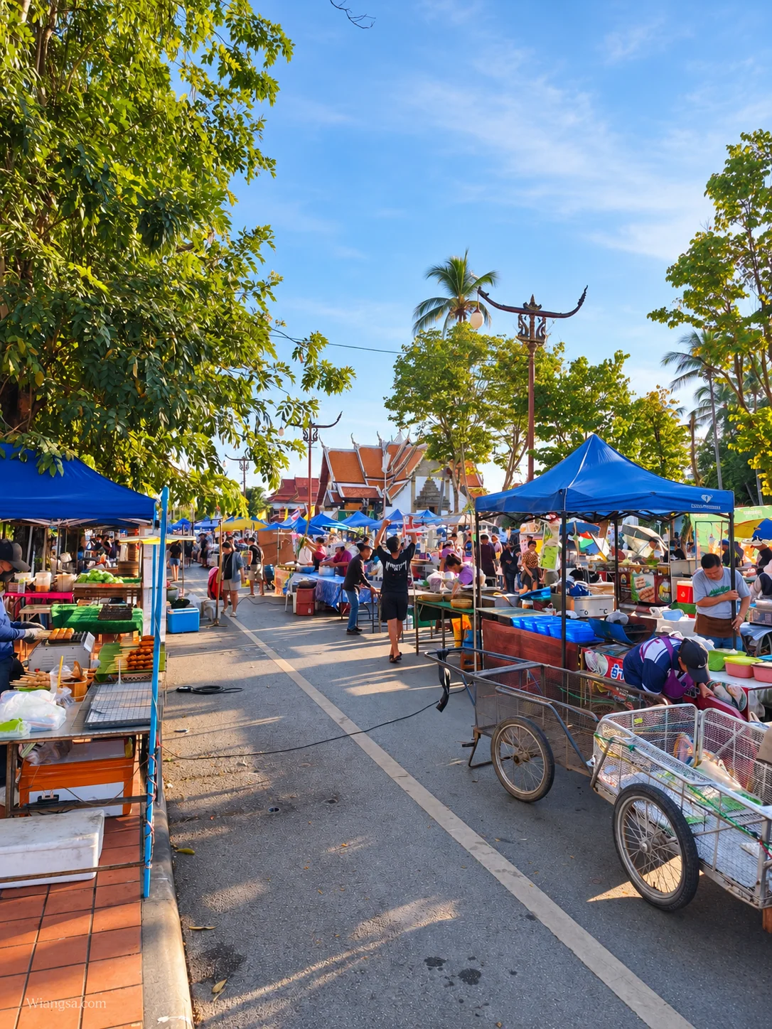 บรรยากาศถนนคนเดินกาดข่วงเมืองน่าน มีเต็นท์ร้านค้าและคนเดินเลือกซื้อของ