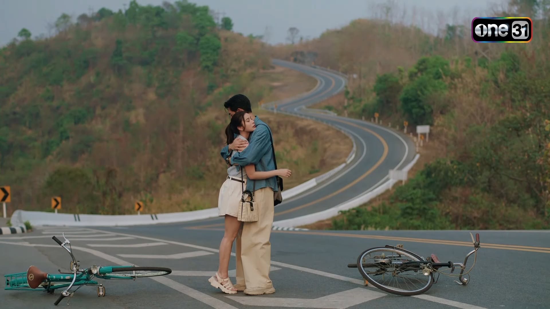 ภาพฉากละครบนพระจันทร์มีกระต่ายจากช่อง one31 มีตัวละครสองคนยืนกอดกันและจักรยานสองคัน โดยมีแนวถนนโค้งเลข 3 ทอดยาวบนภูเขาเป็นฉากหลัง