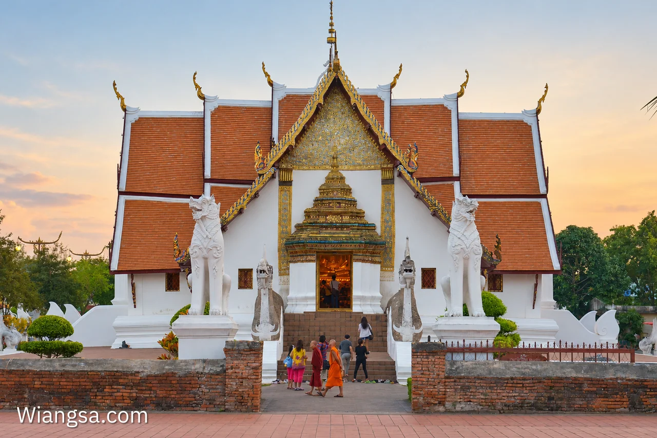 ด้านหน้าวิหารวัดภูมินทร์ หลังคาล้านนาซ้อนระดับ หน้าบันลายทอง พญานาคขนาบบันไดและทางเข้าวิหาร