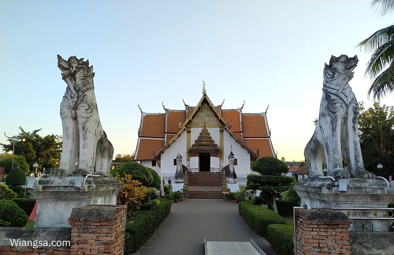 ทางเข้าวัดภูมินทร์ มีประติมากรรมพญานาคสีขาวสองฝั่งทางเดินและวิหารอยู่ตรงกลาง